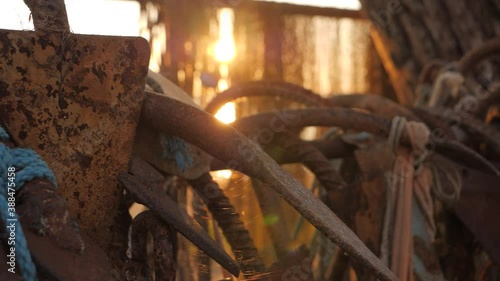 Old rusty anchors hanged in morning sunrise, handheld slow motion. photo