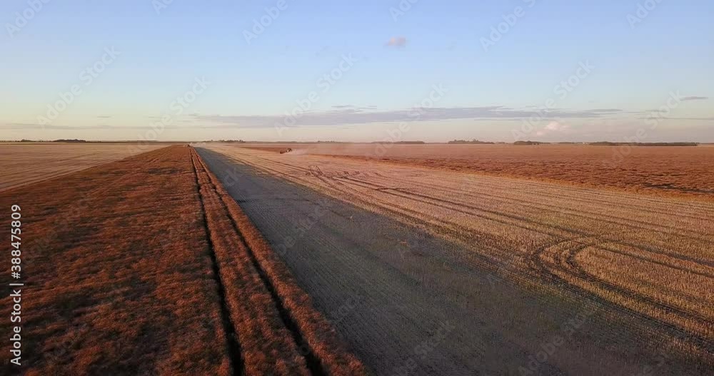 Wide shot of a wheat field being harvested Wide shot of a wheat field being harvested