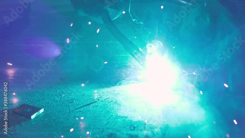 Close-up work with metal steel and iron using a welding machine, bright sparks and flashes in very slow motion photo