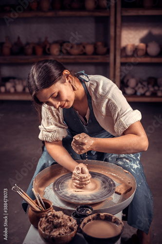Charming ceramist making ceramic pot on the pottery wheel . Concept for woman in freelance, business, hobby. photo