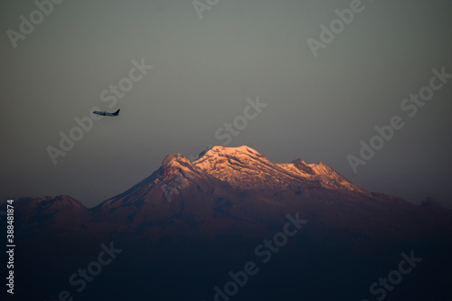 volcan iztacihuatl con avion al atardecer