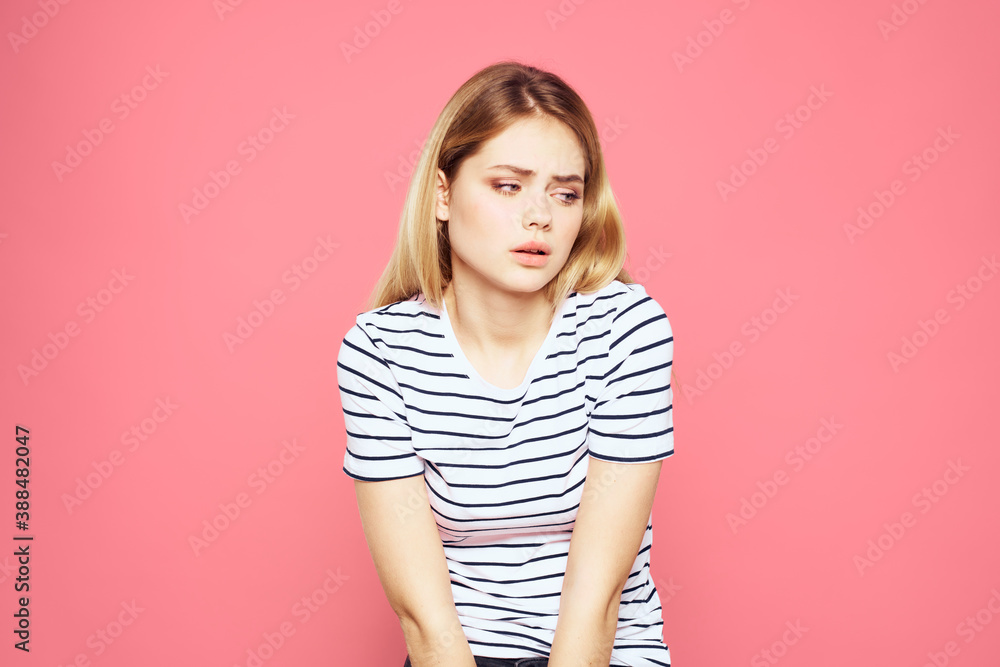 Woman in striped t-shirt emotions studio cropped view lifestyle pink isolated background Woman in striped t-shirt emotions studio cropped view lifestyle pink isolated background