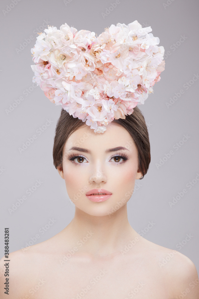 Front beauty portrait. Beautiful girl with spring flowers and bare shoulders. Creative Make up and Hair Style.