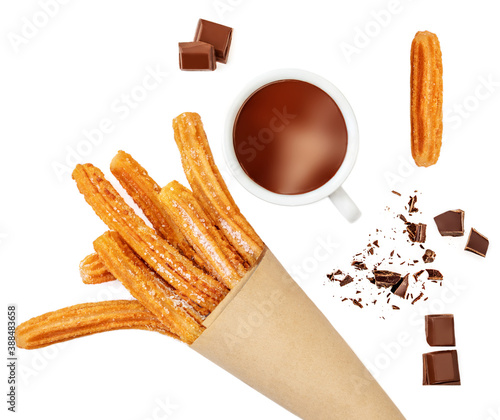 Creative layout made of Churros fried pastry, cup of dark chocolate and chocolate pieces  isolated on a white background, top view. Flat lay. photo