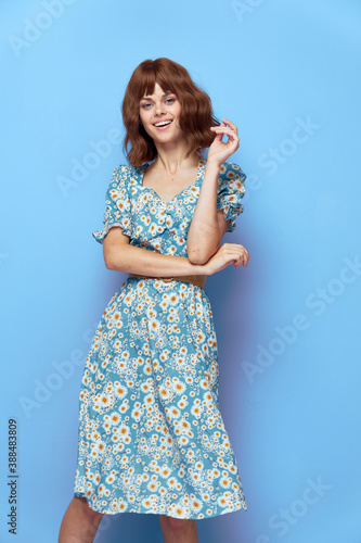 Woman in flower dress smile hand near face short hair 