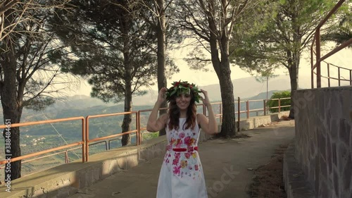 Giovane ragazza con vestito bianco si laurea. Corona di alloro in testa simbolo trionfale italiano. photo