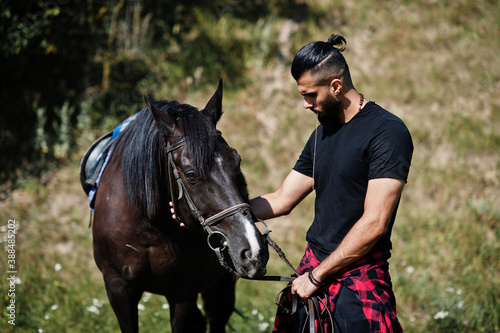 Arab tall beard man wear in black with arabian horse. © AS Photo Family
