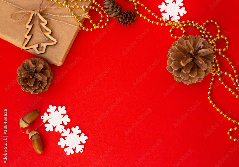 Fototapeta premium On a red table in a Christmas tree cones and a gift Christmas background