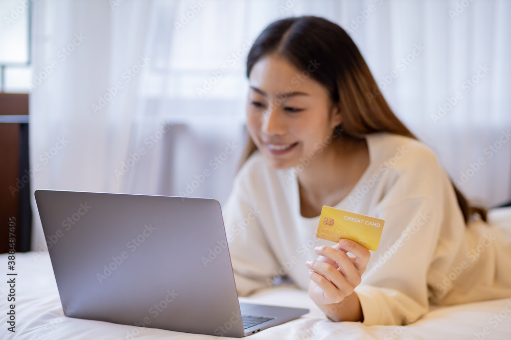 Asian woman buy items from the internet with laptop by use credit card. Asian woman buy items from the internet with laptop by use credit card.