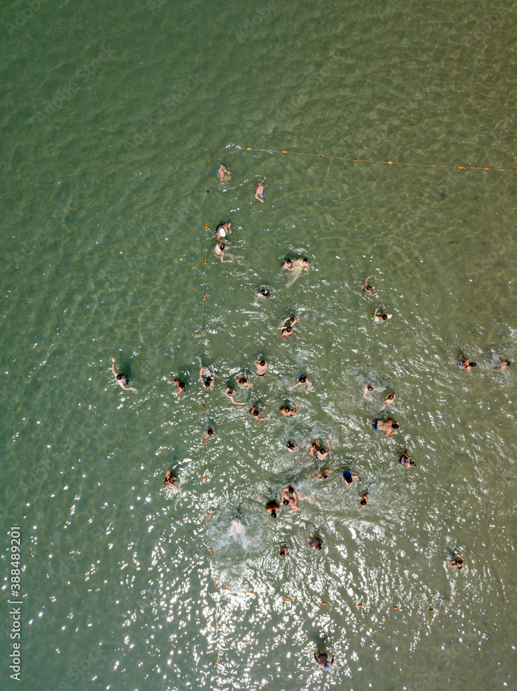 Sochi / Russia - June 26 2018: View from above on tourists swimming relaxing with inflatable mattresses in calm turquoise water in the sea, summer vacation on the beach. Black sea, Aerial. Sochi / Russia - June 26 2018: View from above on tourists swimming relaxing with inflatable mattresses in calm turquoise water in the sea, summer vacation on the beach. Black sea, Aerial.