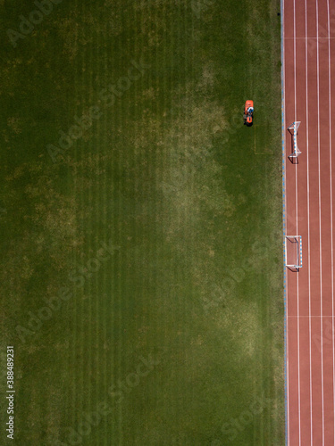 Fotografija Aerial top down view of man mowing grass on football stadium