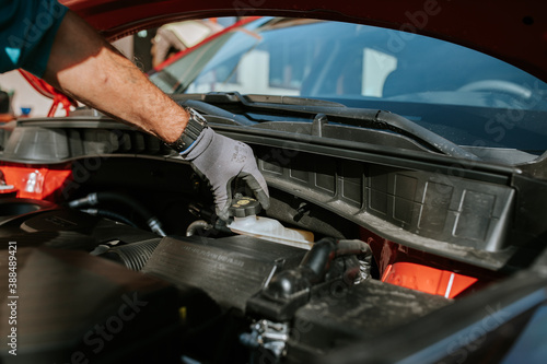 Mechanic examinates the cars technical conditions. Exterior view of a new car