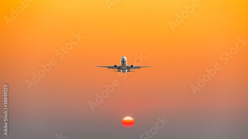Commercial airplane flying above clouds in colorful sunset.Travel,holidays and business concept. © ABCDstock