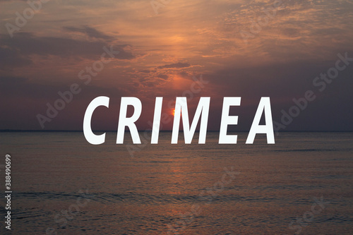 The inscription Crimea on the background of the sunset at sea.