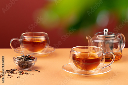Glass teapot and two glass cups with tea