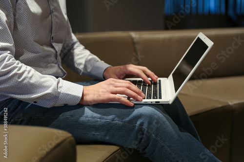 man's hands are typing on laptop in the waiting room