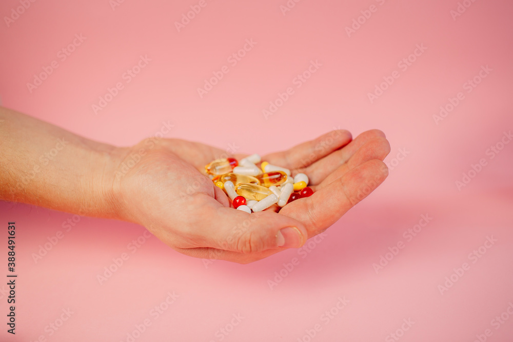 some medicine of various shape and colors on the man's hand some medicine of various shape and colors on the man's hand