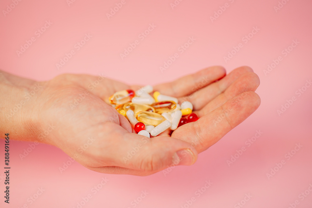 some medicine of various shape and colors on the man's hand some medicine of various shape and colors on the man's hand