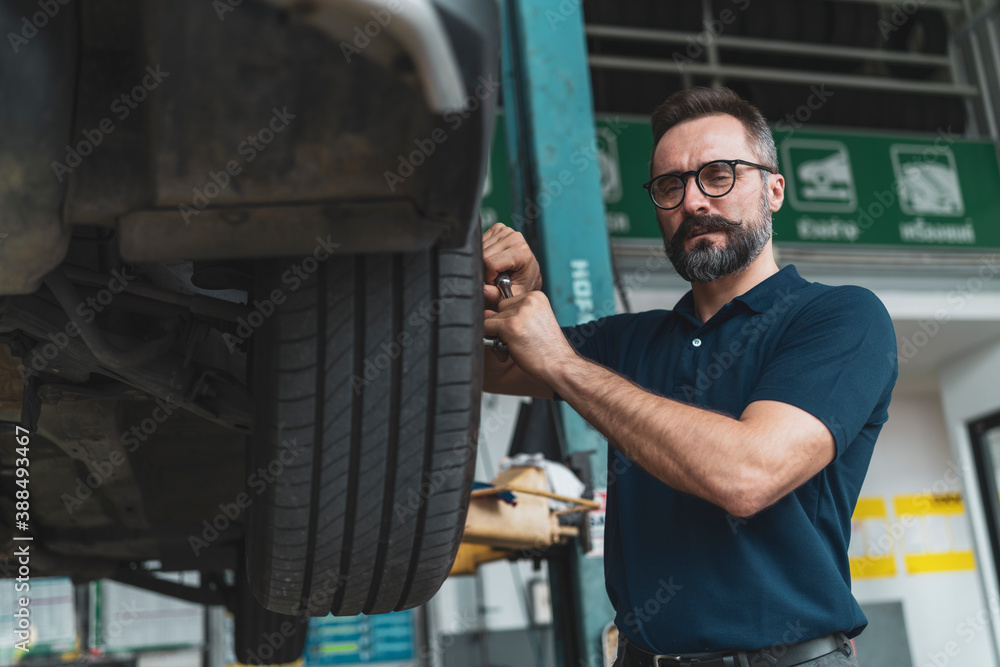 A senior auto mechanic working in garage, car repair services A senior auto mechanic working in garage, car repair services