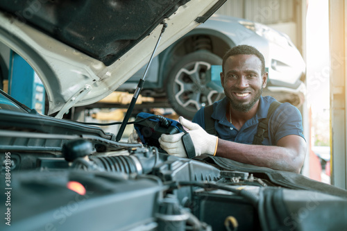 Auto mechanic working in garage, car repair services