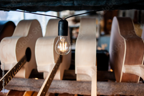 Parts of guitar hanging on the shelves at the factory