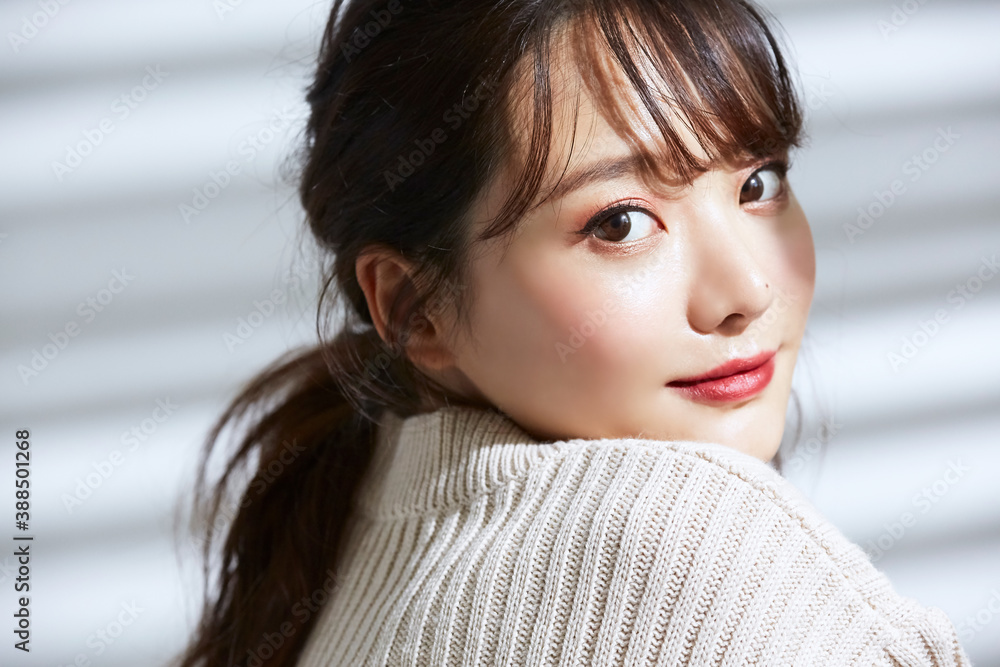 Naklejka premium 光と影の背景の若い女性のビューティーポートレート