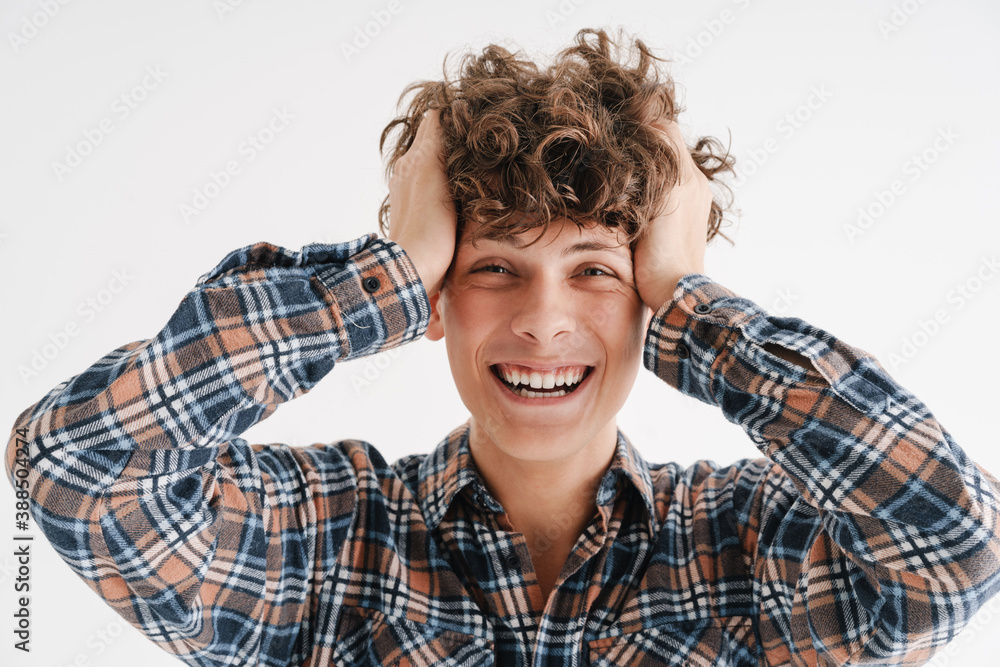 Cheerful curly guy laughing and grabbing his head Cheerful curly guy laughing and grabbing his head