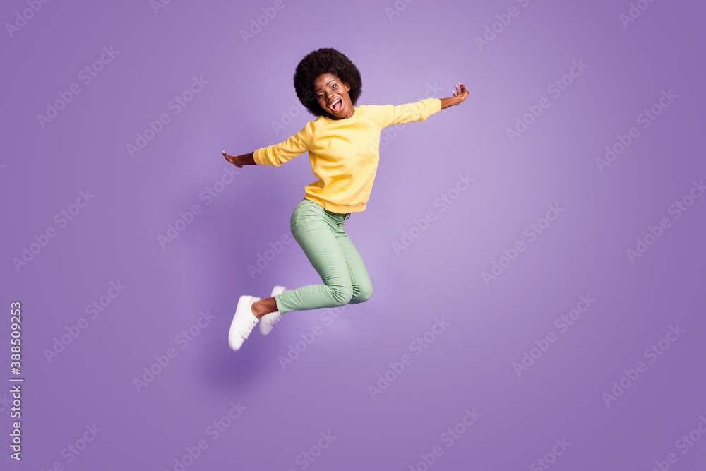 Full body photo of crazy afro american girl jump hold hands plane flying game concept isolated on violet color background