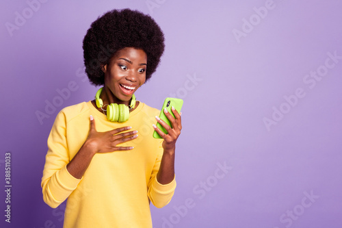 Photo of excited dark skin girl read unexpected social media news smartphone wear yellow sweater isolated on violet color background