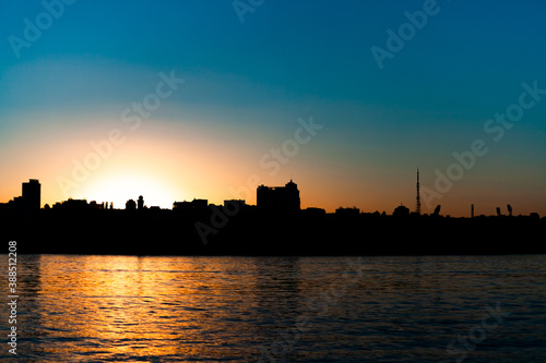 sunset over the city, the sun sets over the horizon, clear sky, in the foreground of the river, use as a background or text