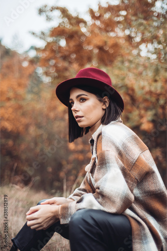 Young woman fashionably dressed in a dry autumn forest