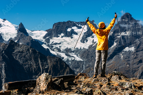 A woman traveling in the Caucasus. Mountain sports. Athlete happy finish. Mountain tourism. Walking tour. The journey to the mountains. Nordic walking among the mountains. Copy space