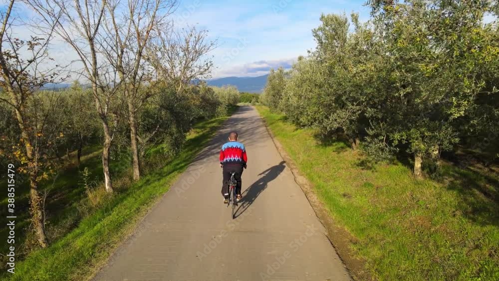 A boy rides a bicycle followed and filmed by a drone A boy rides a bicycle followed and filmed by a drone