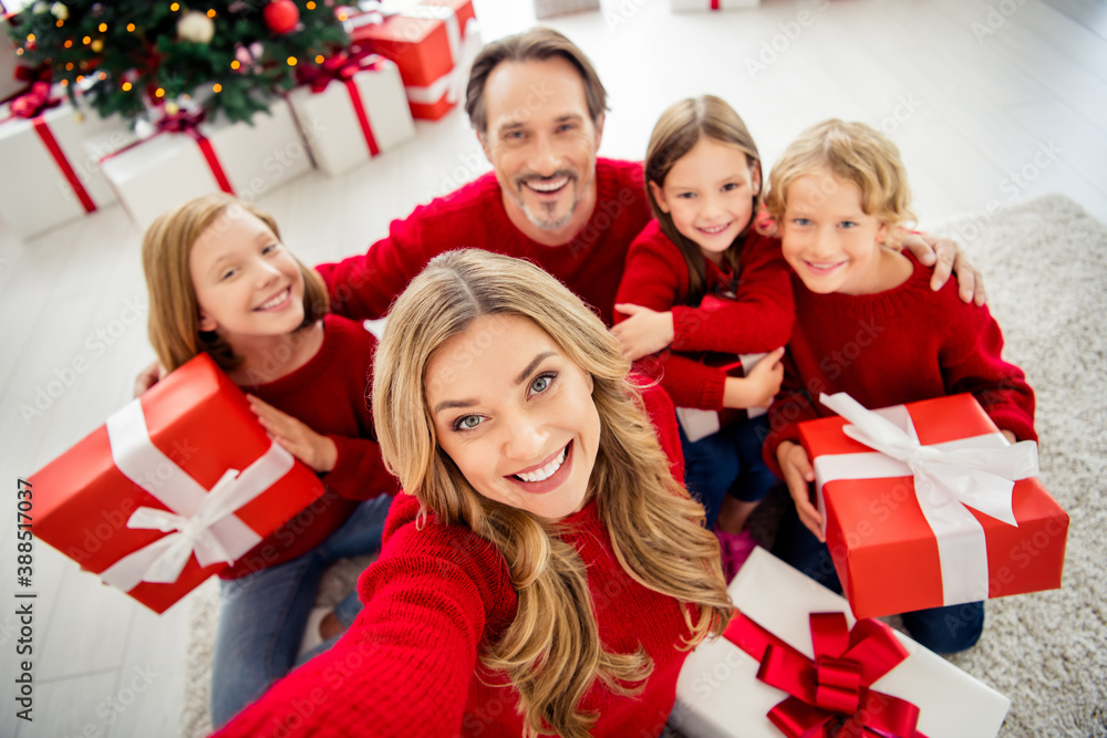 Photo of full big family five people gathering three small kids sit floor hold present box mom make shoot selfie wear red jumper in living room x-mas tree lights many gifts indoors Photo of full big family five people gathering three small kids sit floor hold present box mom make shoot selfie wear red jumper in living room x-mas tree lights many gifts indoors