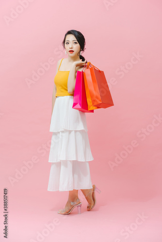 beautiful young woman holding colored shopping bags