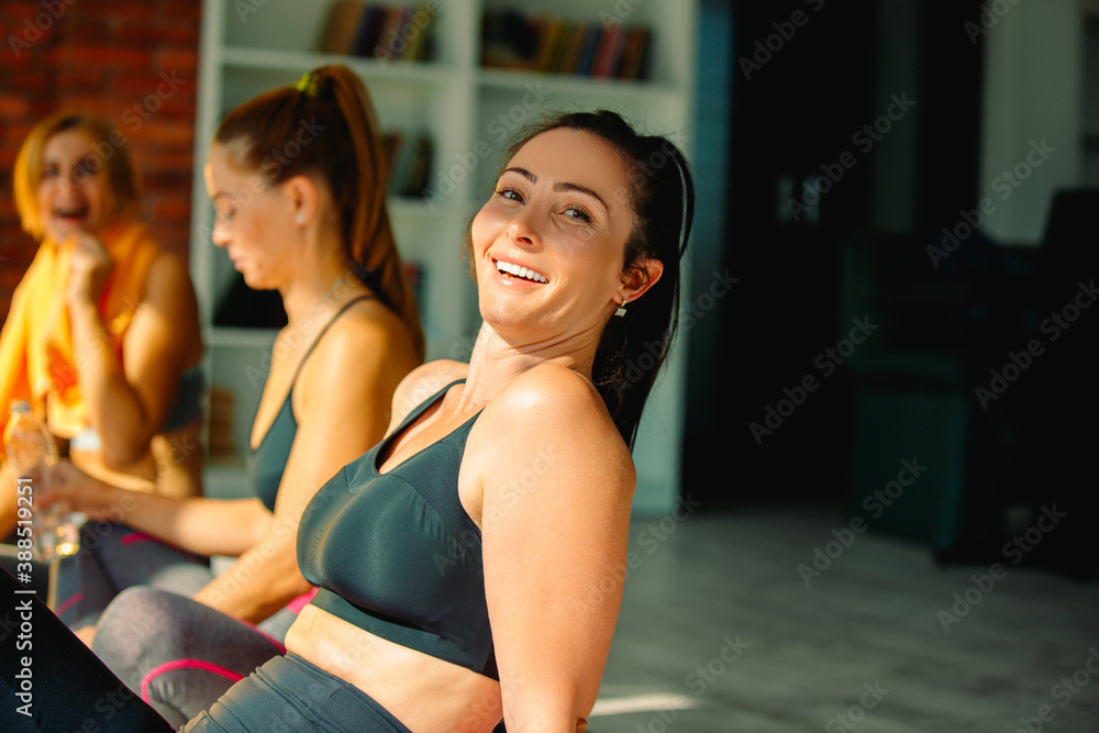 Happy fitness girls relax on yoga mat after workout enjoying the results. Healthy lifestyle, healthy thoughts