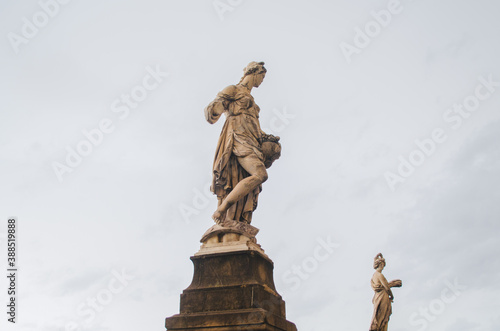 Florence, Italy - Delicate feminine statues in degradation process representing 2 of the 4 seasons with a cloudy background.