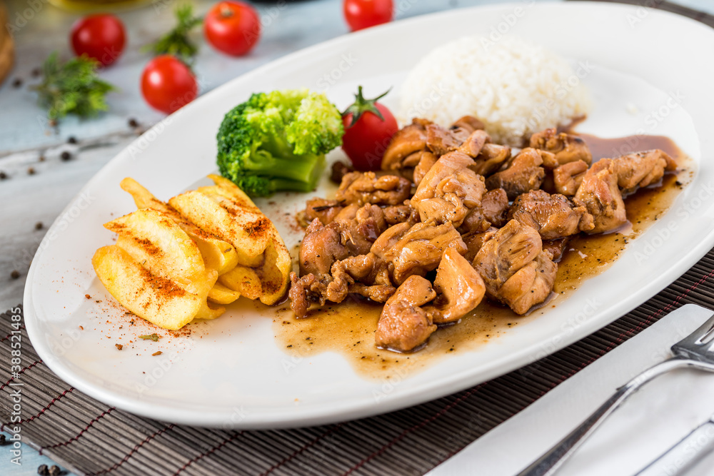 grilled chicken with rice and fried potatoes on white plate grilled chicken with rice and fried potatoes on white plate