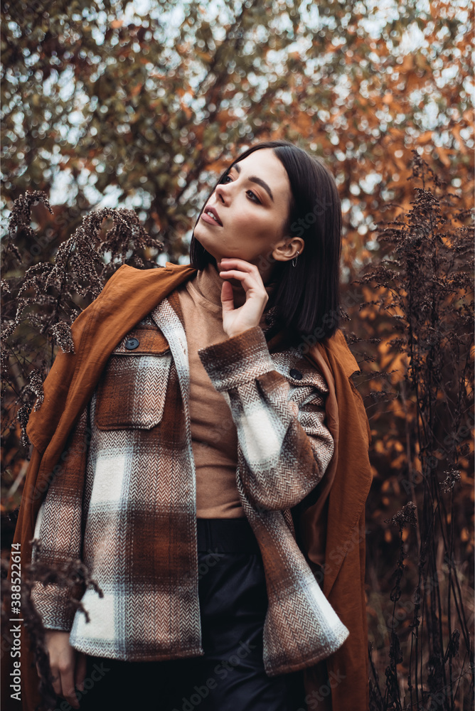 Obraz premium Outdoor fashion photo of young beautiful lady in autumn landscape with dry flowers. Knitted sweater, wine lipstick. Warm Autumn. Warm Spring