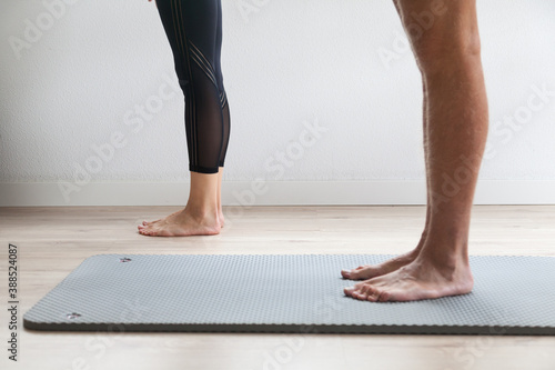 Legs of two people practicing yoga on a yoga mat