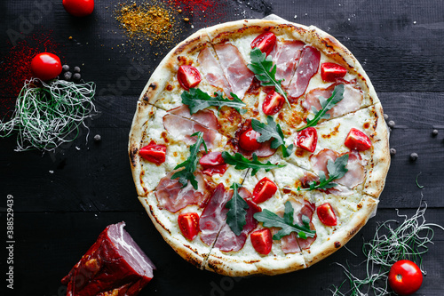Thin pizza with ham and tomatoes