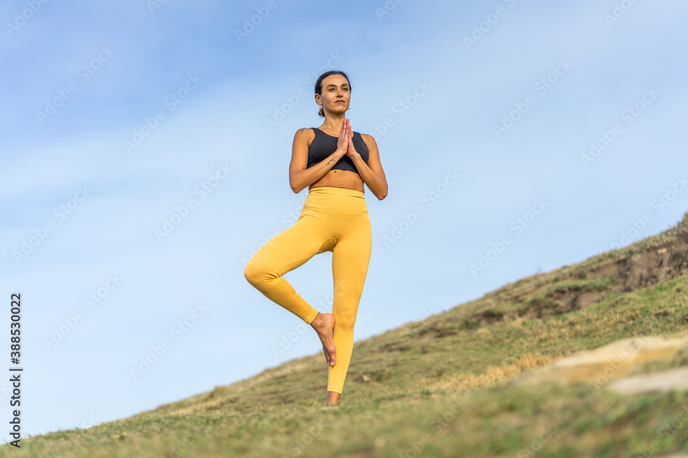 Middle-aged woman practicing yoga outdoors in the middle of the bush Middle-aged woman practicing yoga outdoors in the middle of the bush