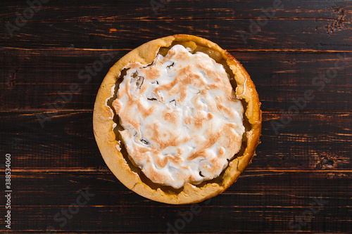 Pear pie with cream, homemade pastries on wooden table. Copy space.