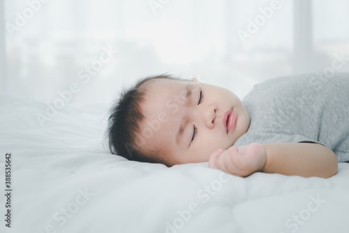 Asian little baby girl sleeping on bed.