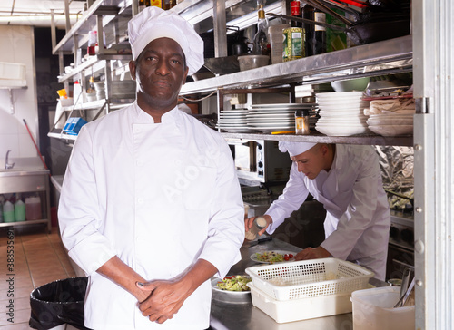 Tableau sur toile portrait of smiling male chef standing in modern kitchen