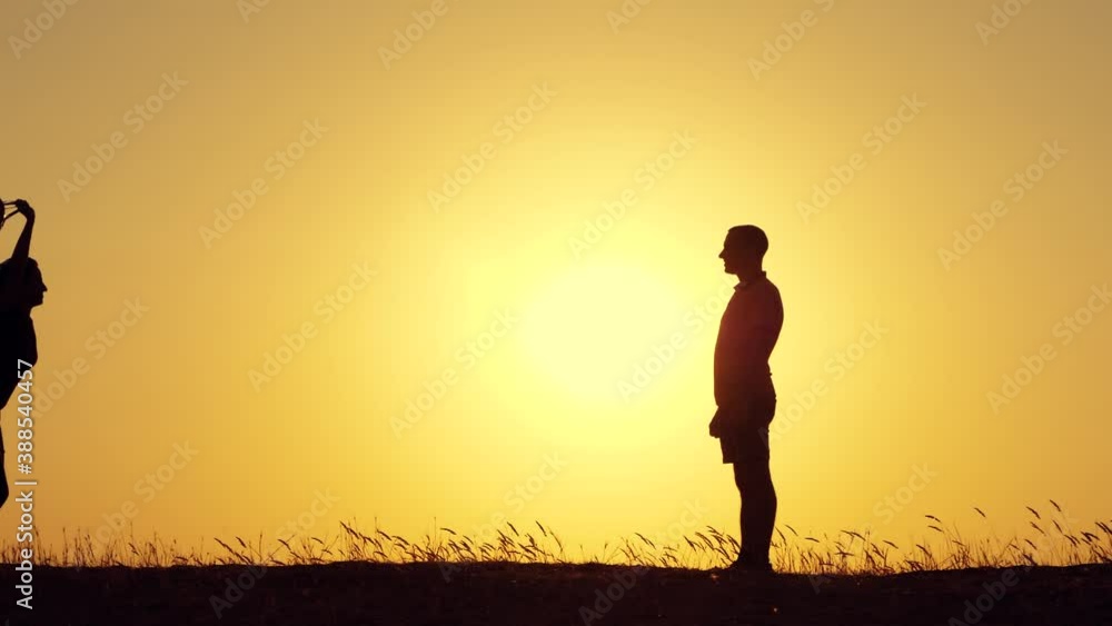 Silhouette of a happy woman and man. A girl with balloons runs to the man. Silhouette of a happy woman and man. A girl with balloons runs to the man.