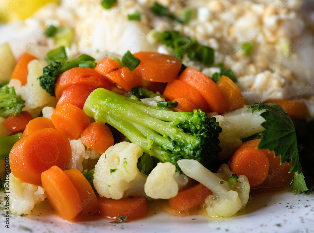 Fish meal served with various vegetables, blurry motion, focus to carrots, Fish meal served with various vegetables, blurry motion, focus to carrots,
