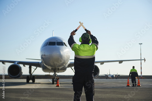 The runway traffic controller uses gestures and sticks to help the aircraft choose the correct trajectory around the airfield
