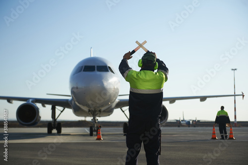 The runway traffic controller uses gestures and sticks to help the aircraft choose the correct trajectory around the airfield photo