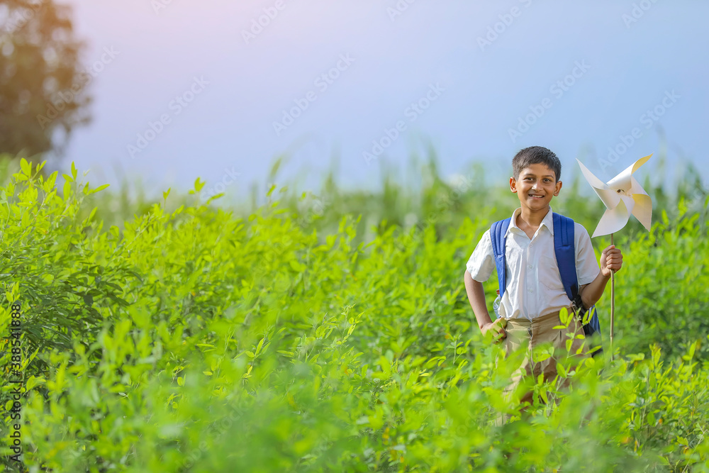 indian child running and playing with pinwheel